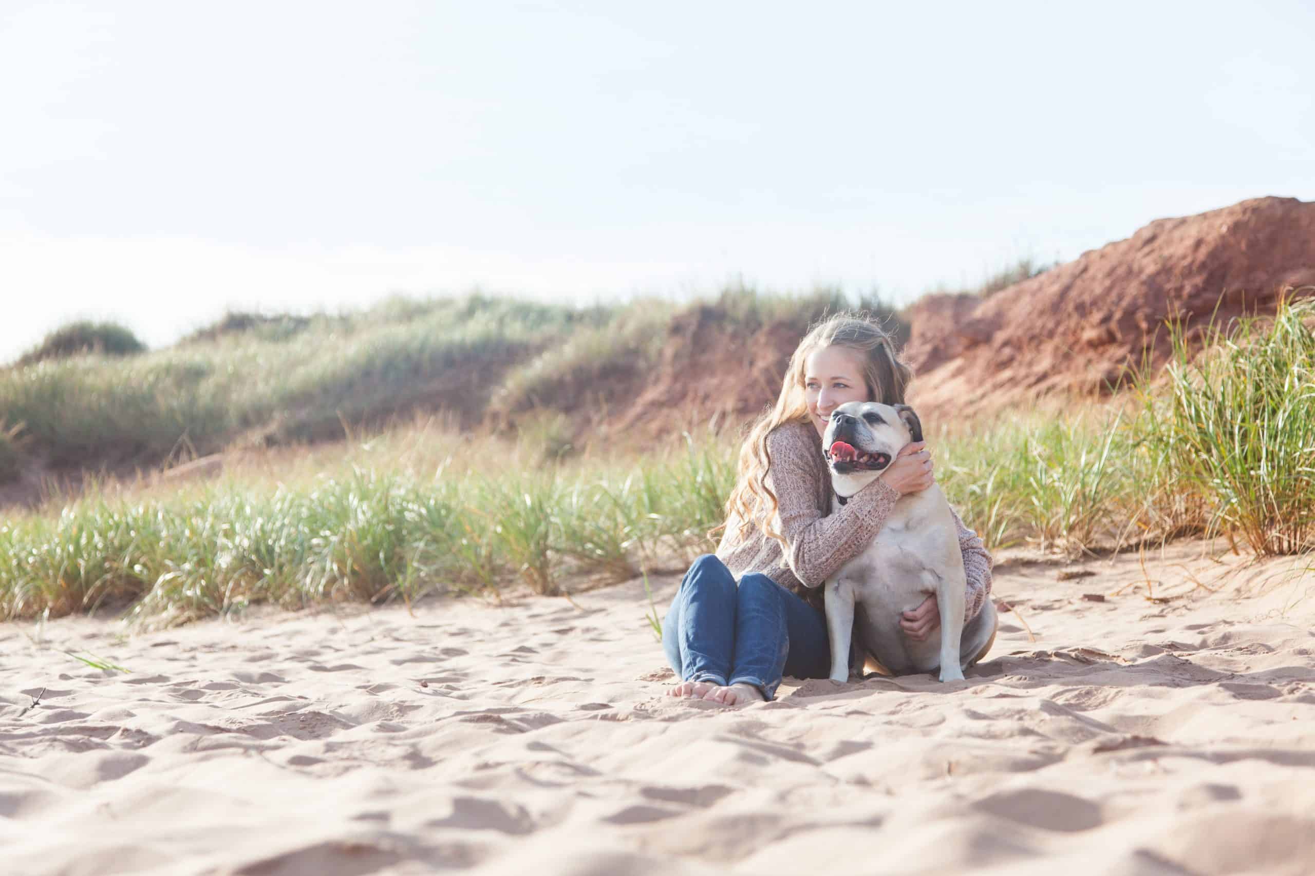 female-at-the-beach-smiling-with-dog