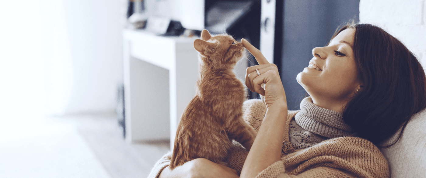 smiling-woman-playing-with-pet-cat