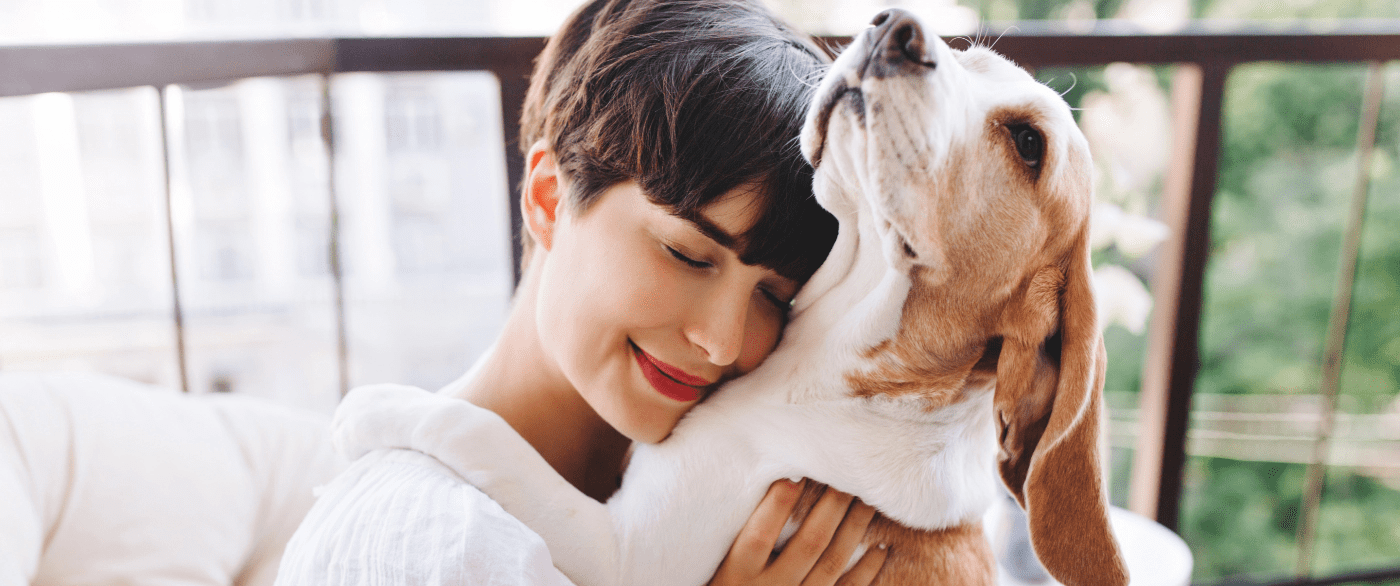 Beautiful-Young-Woman-Working-At-Home-And-hugging-Her-Dog
