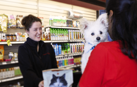 staff-warmly-welcoming-customer-with-dog